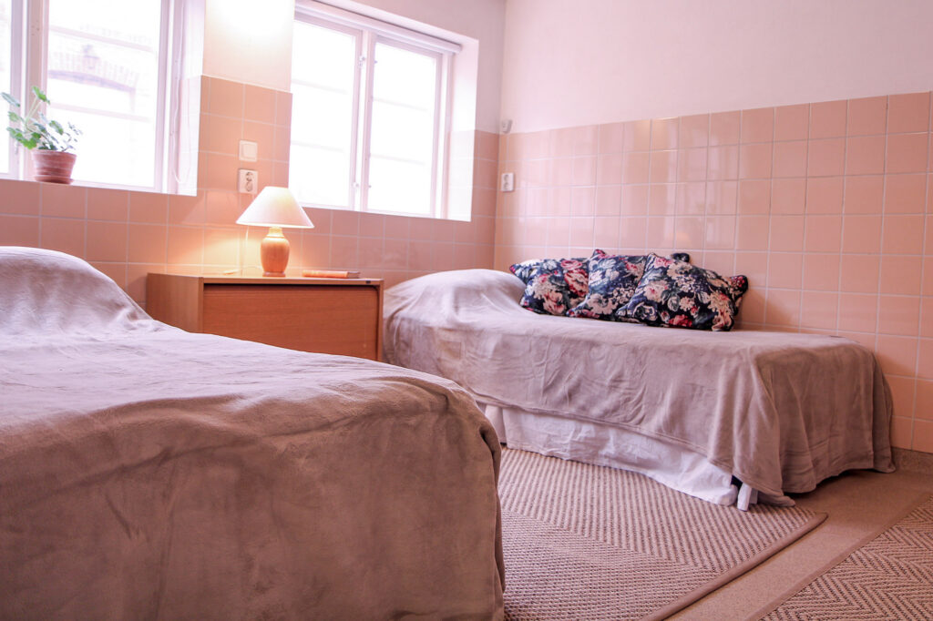 Dubbelrummet med två 90 cm breda sängar, nattygsbord och jutemattor på golvet.